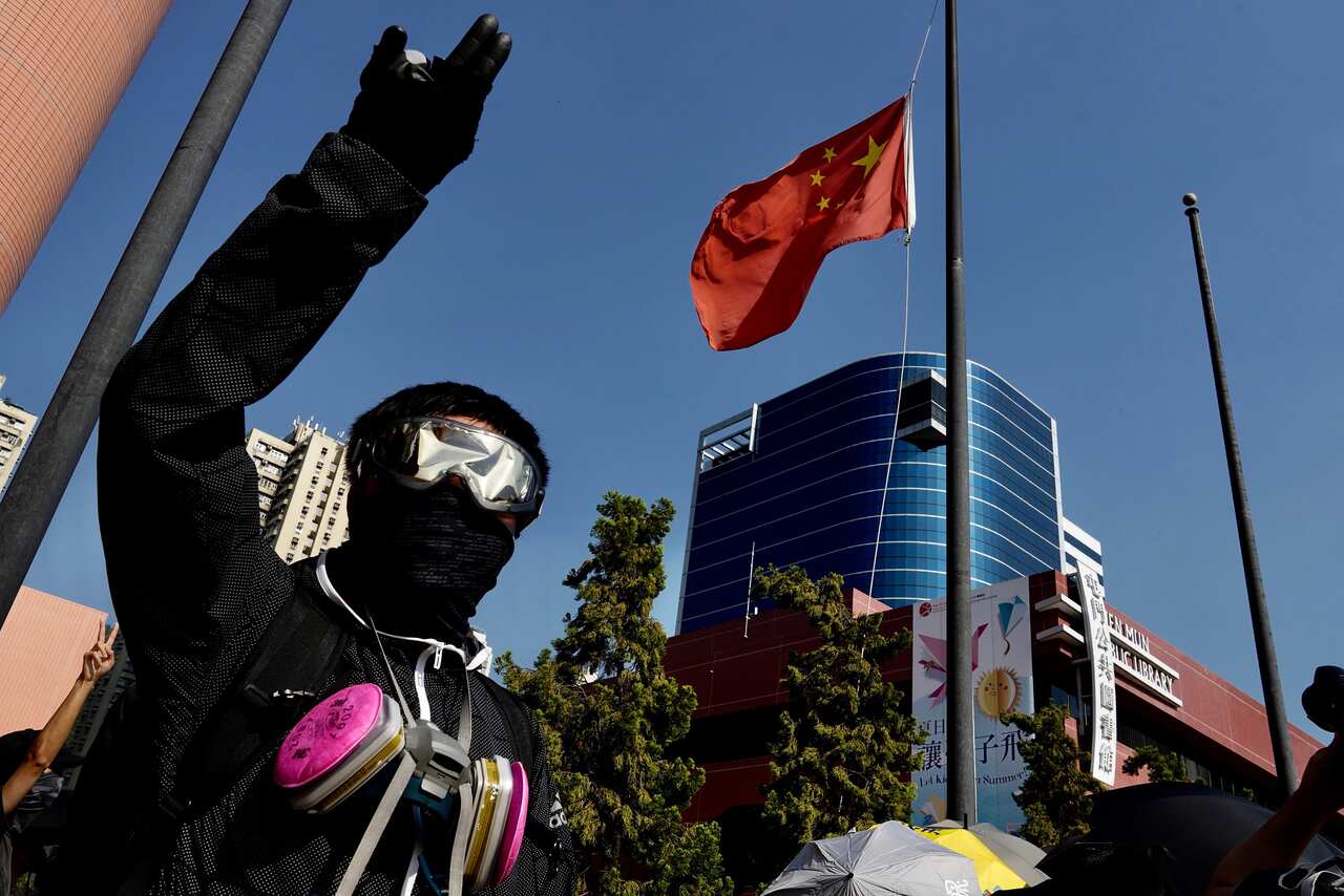 Protesters lower a Chinese national flag which they later set on fire in Hong Kong.