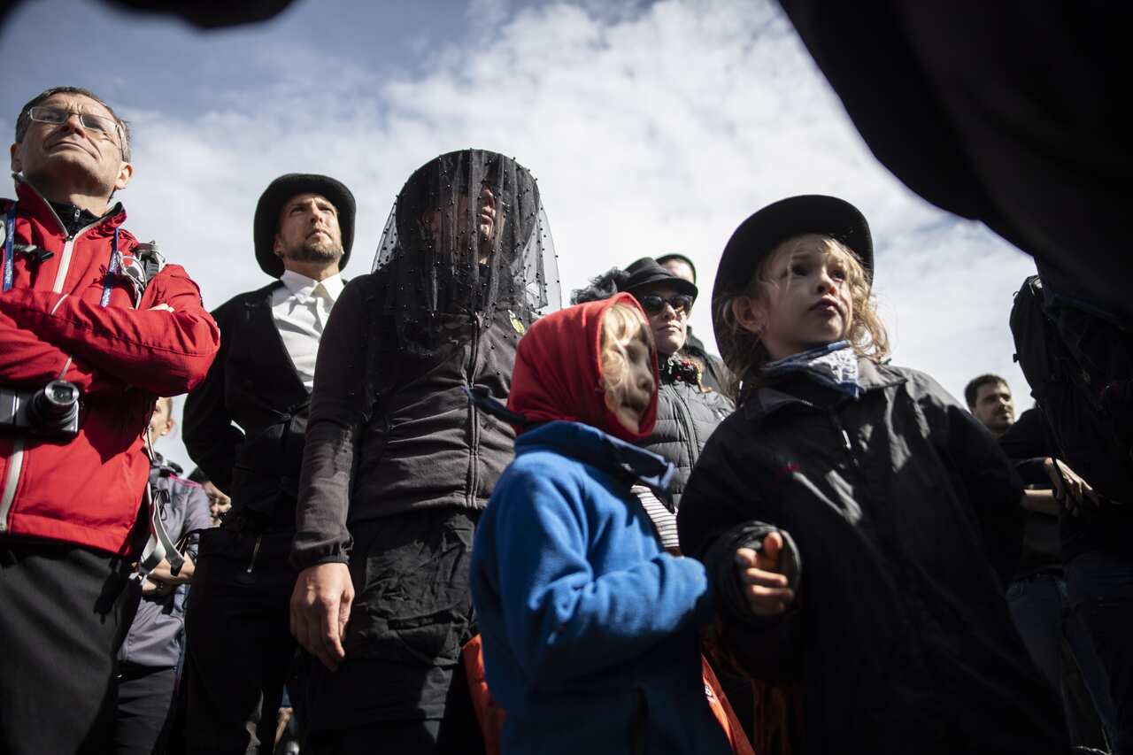 People in black clothing attend a commemoration for the dying glacier of Pizol mountain, in Wangs, Switzerland.