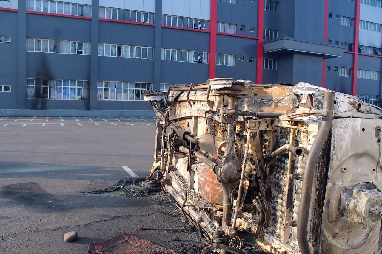 A burnt car that was allegedly torched by protesters, sits on the road during a violent rally in Wamena, Papua Province, Indonesia.