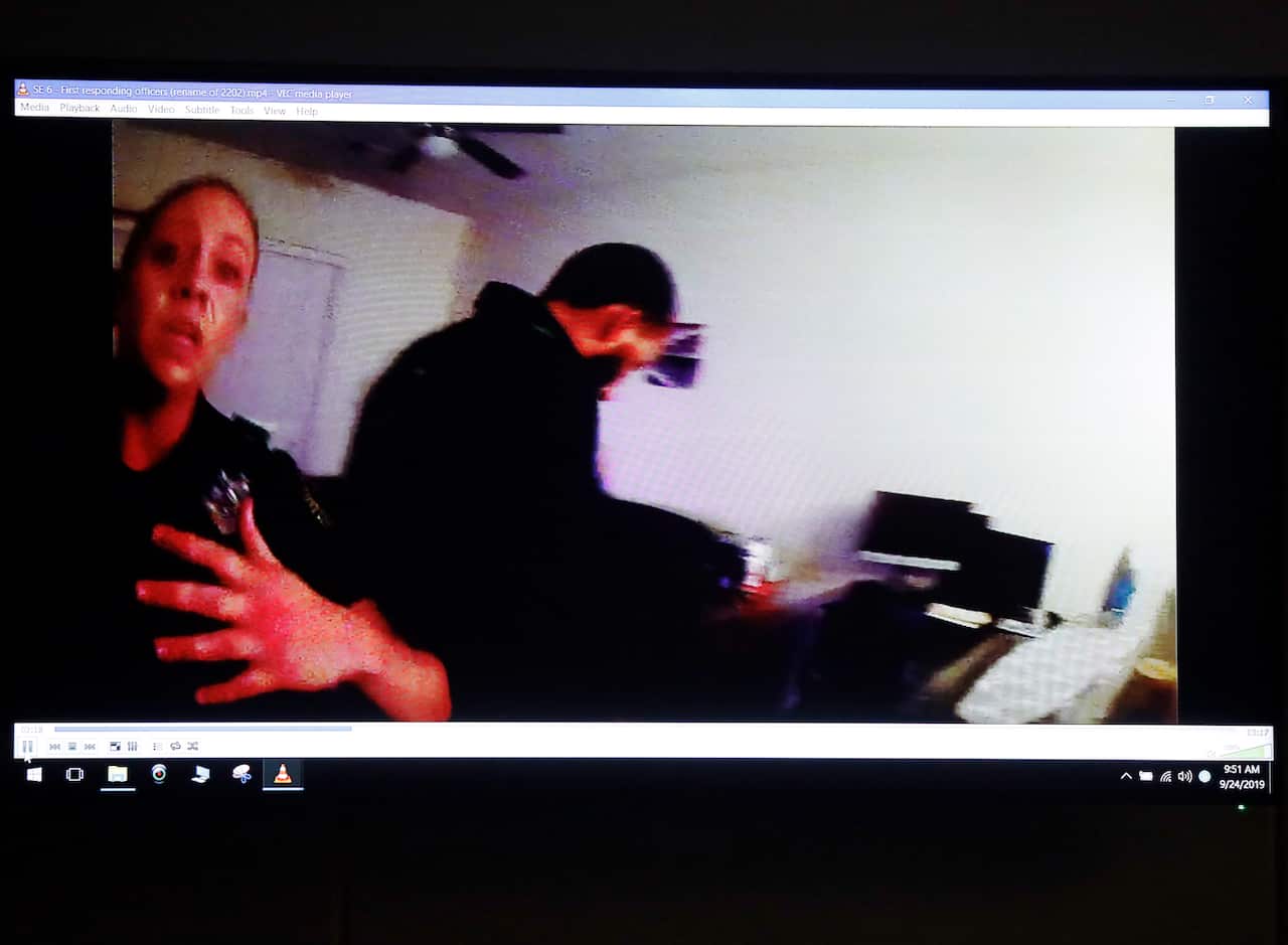 A panicked Dallas police officer Amber Guyger (left) is pictured on police body cam footage in Botham Jean's apartment as Dallas Police arrive. 