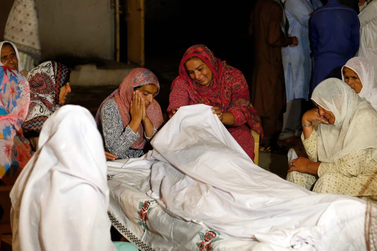 Women mourn beside the dead body of their family member Sabir Hussain, who died in a house collapse after a powerful earthquake struck in Sahang Kikri village near Mirpur, in northeast Pakistan, Tuesday, Sept. 24, 2019.  (AP Photo/Anjum Naveed)