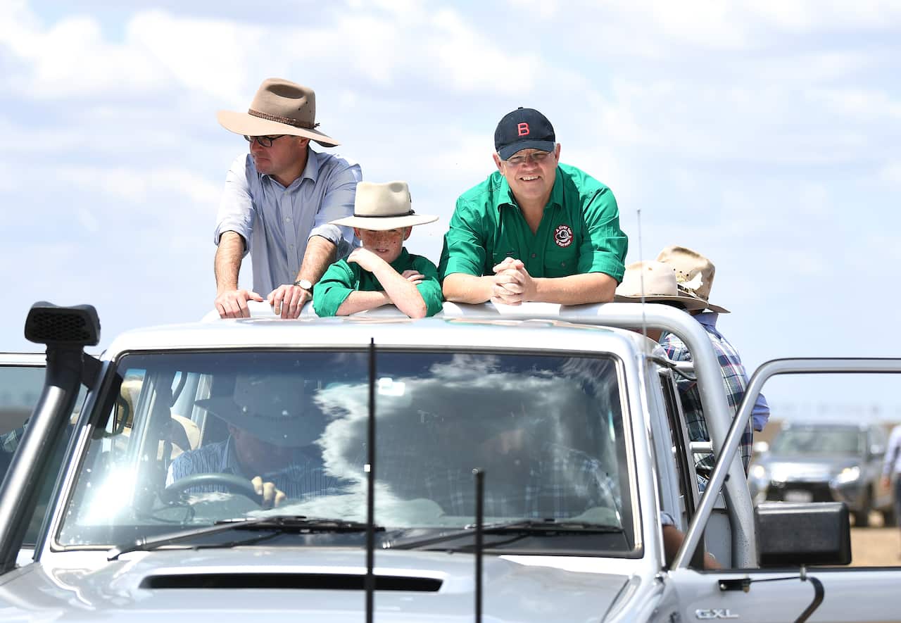Prime Minister Scott Morrison (right) and Agriculture Minister David Littleproud are seen on the back of a ute during a visit to a drought-affected property.