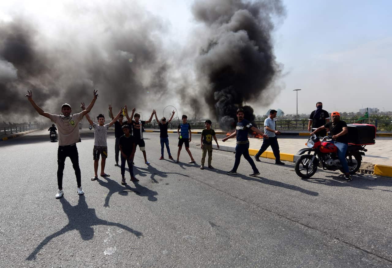 Iraqi demonstrators burn tires during clashes and protests at Baladiyat district, eastern Baghdad, Iraq.