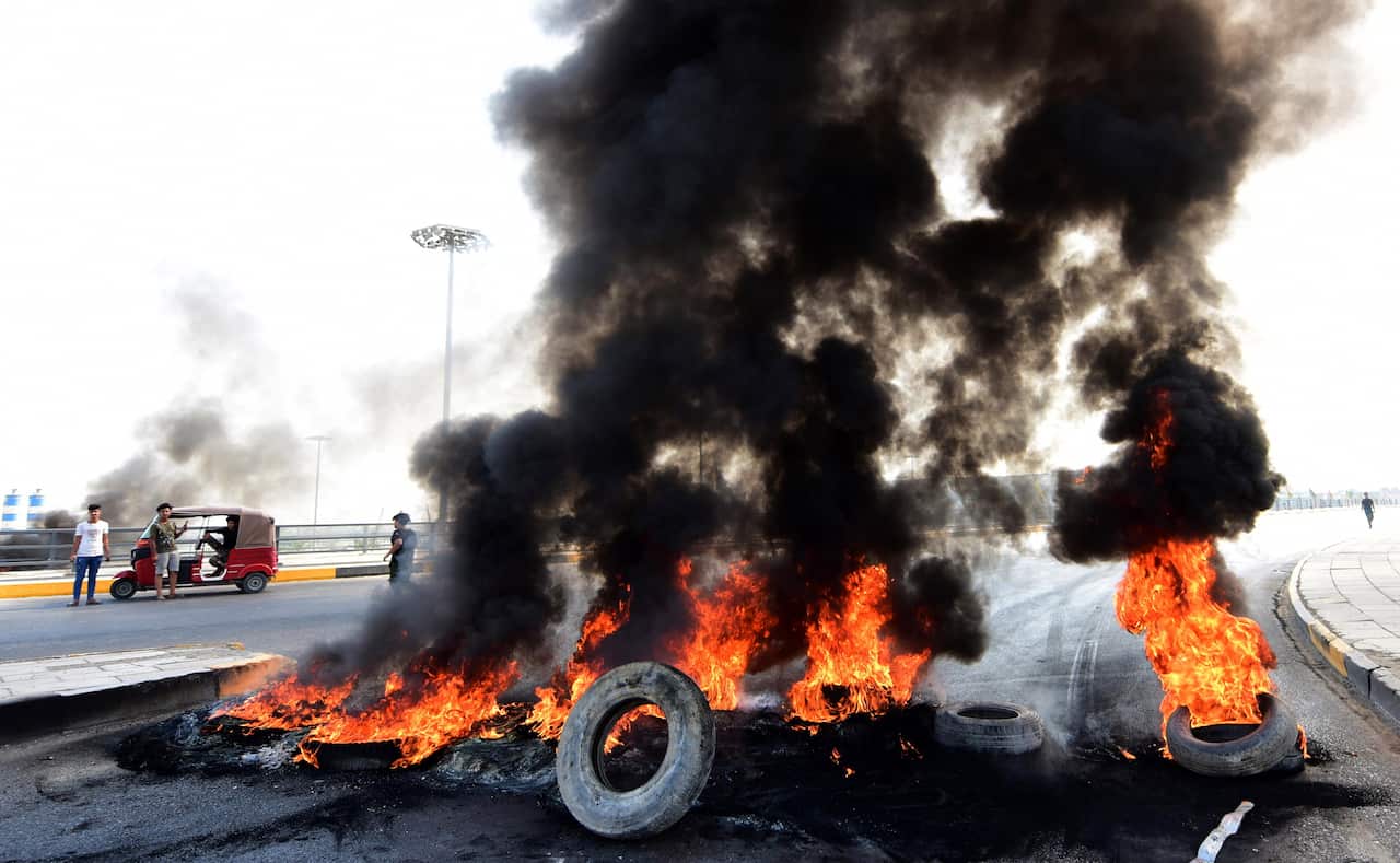 Iraqi demonstrators burn tires during clashes and protests at Baladiyat district, eastern Baghdad, Iraq.
