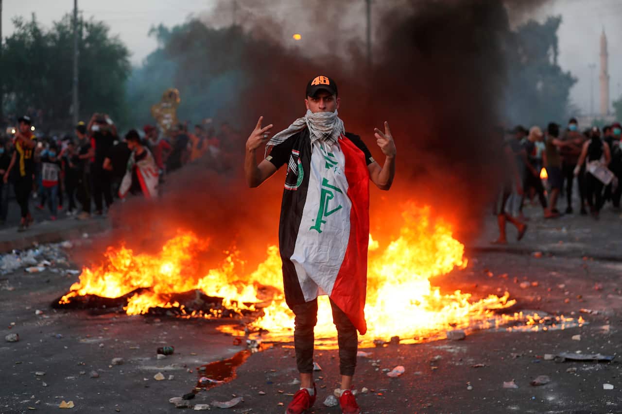 An anti-government protester flashes the victory sign during a demonstration, in Baghdad, Iraq.
