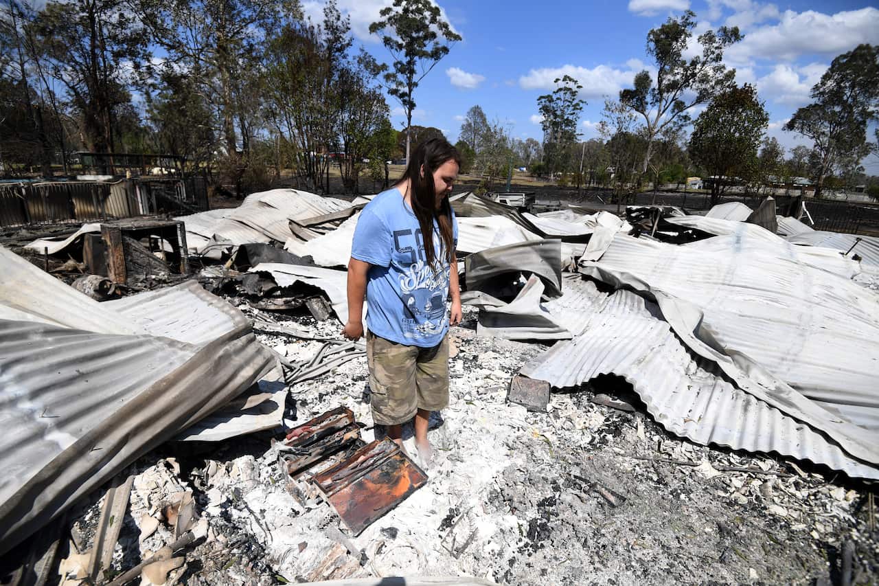 Liam McKenzie inspects the remains of his house which was destroyed by bushfires in Rappville, NSW.