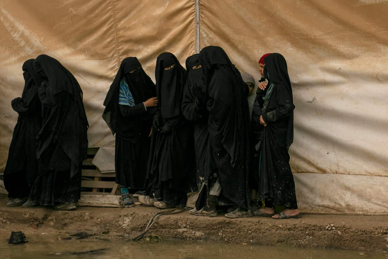 Women queue for aid supplies at al-Hol camp, home to Islamic State-affiliated families.