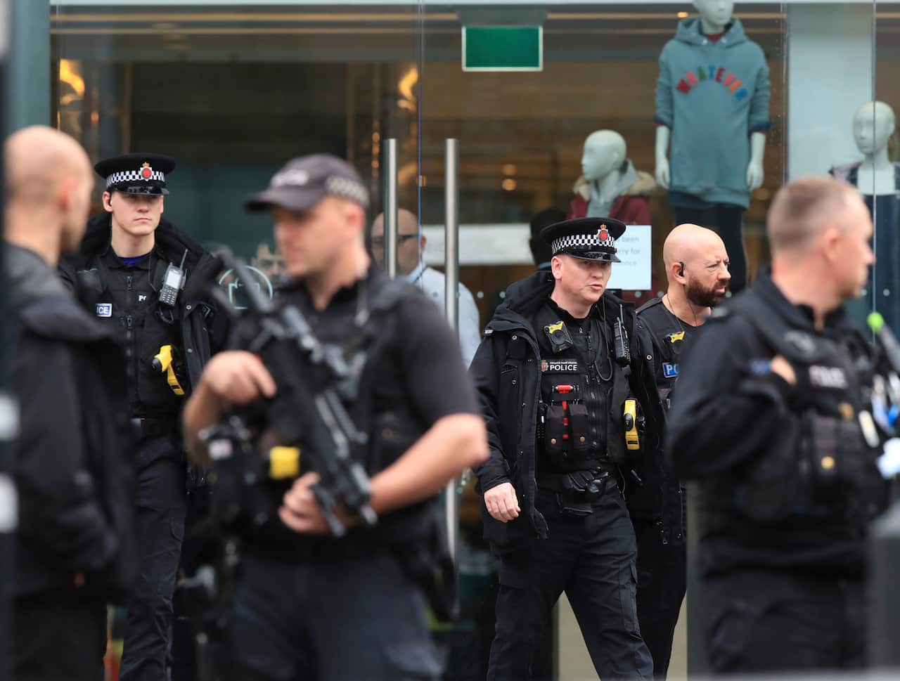 Armed police officers patrol outside the Arndale Centre in Manchester, England.