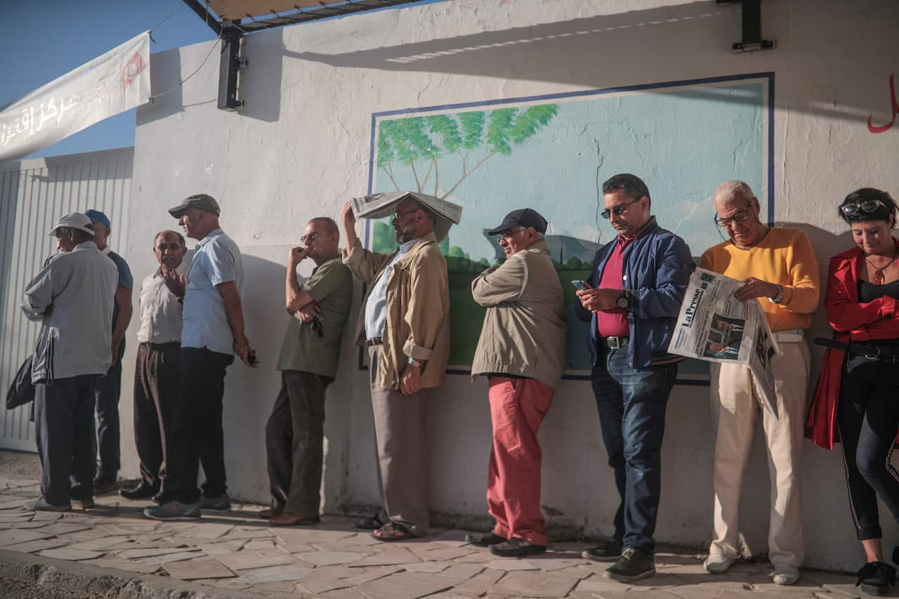 People queue outside a polling station during the second round of the presidential election, in Tunis, Tunisia, Sunday, Oct. 13, 2019. Tunisians are voting for president, choosing between a law professor and populist tycoon. (AP Photo/Mosa'ab Elshamy)