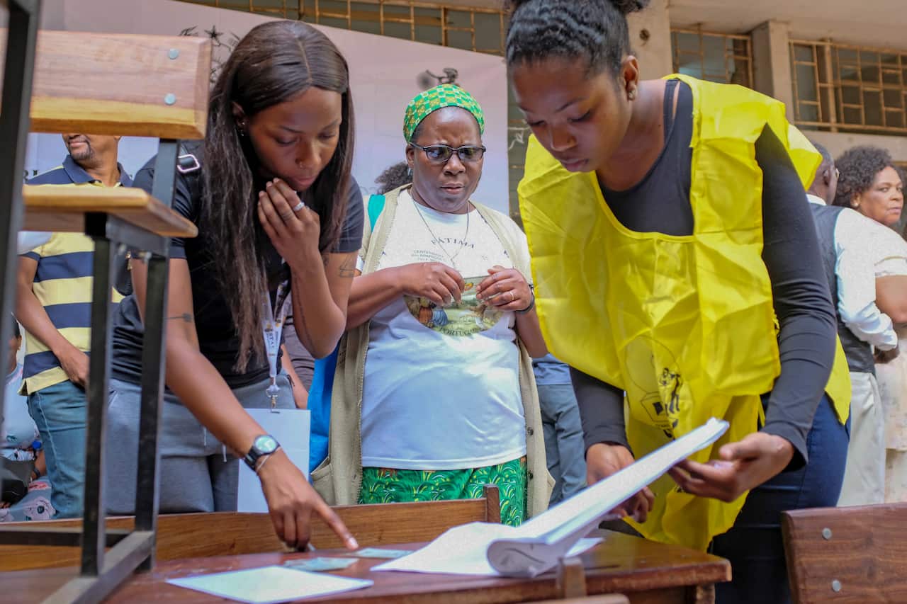 Electoral officials check an electoral roll at a polling station in Maputo, Mozambique.