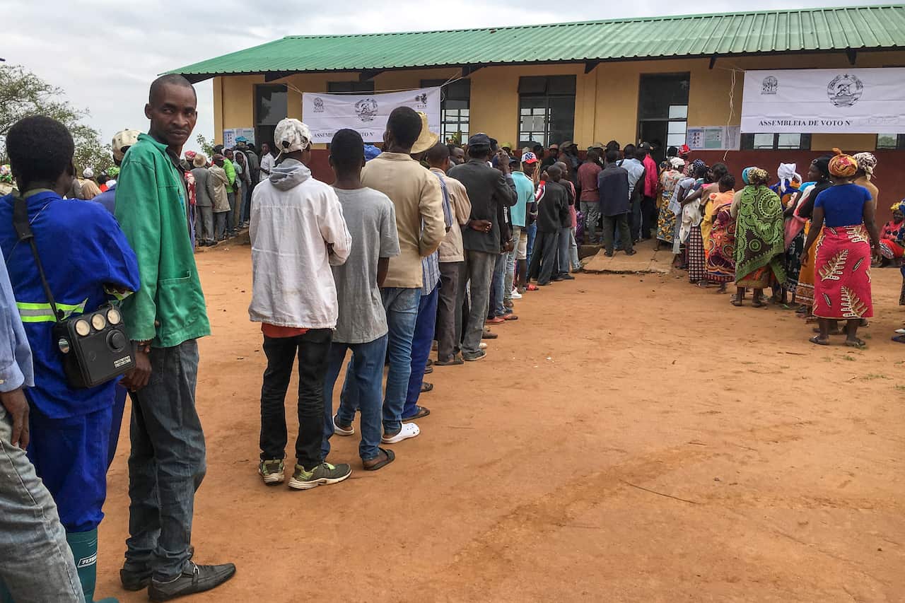 People wait in line prior to vote outside a polling station in Chimoio, Manica Province, Mozambique.