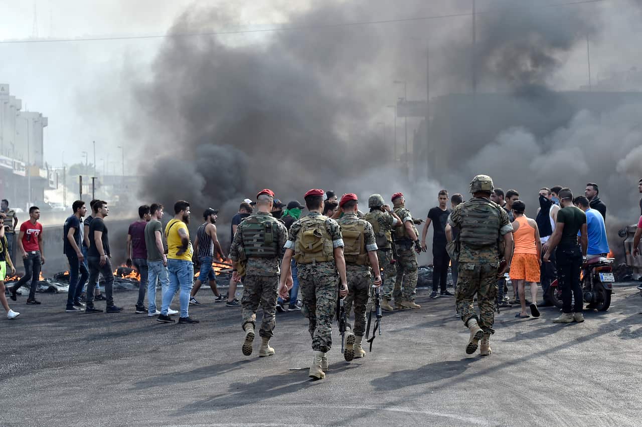 Lebanese soldiers speak with protesters in an attempt to open a blocked road.