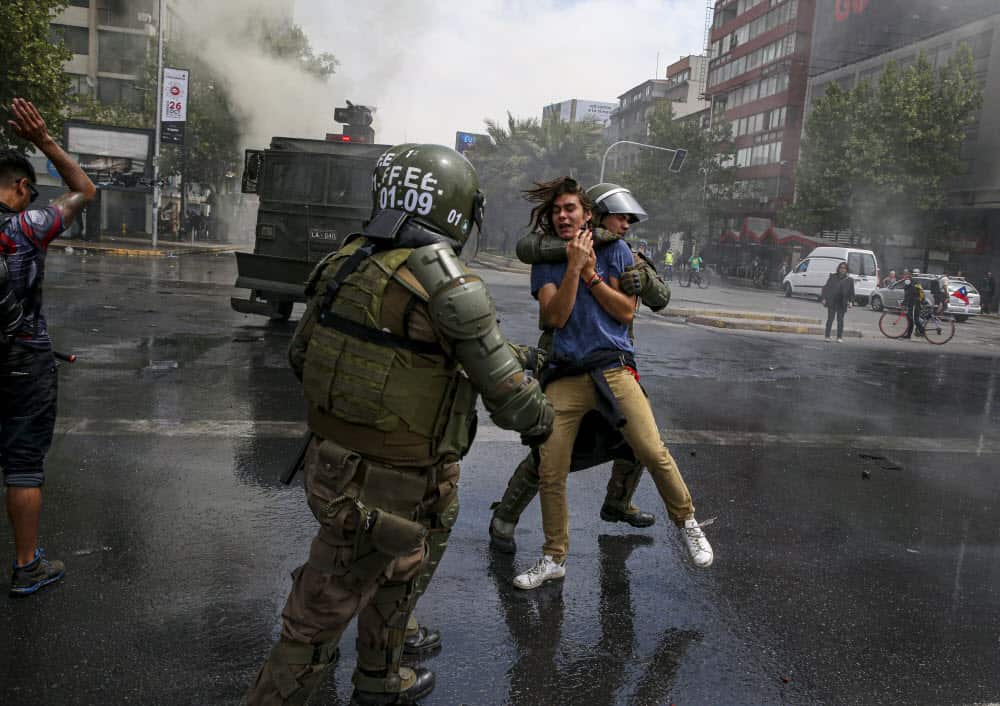 A demonstrator is detained by the police during a protest in Santiago, Chile, Saturday, Oct. 19, 2019