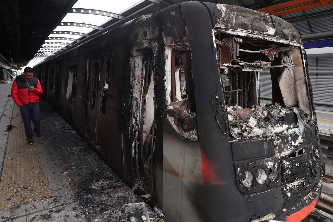 Subway cars burnt by protesters are parked at the Elisa Correa station in Santiago, Chile.