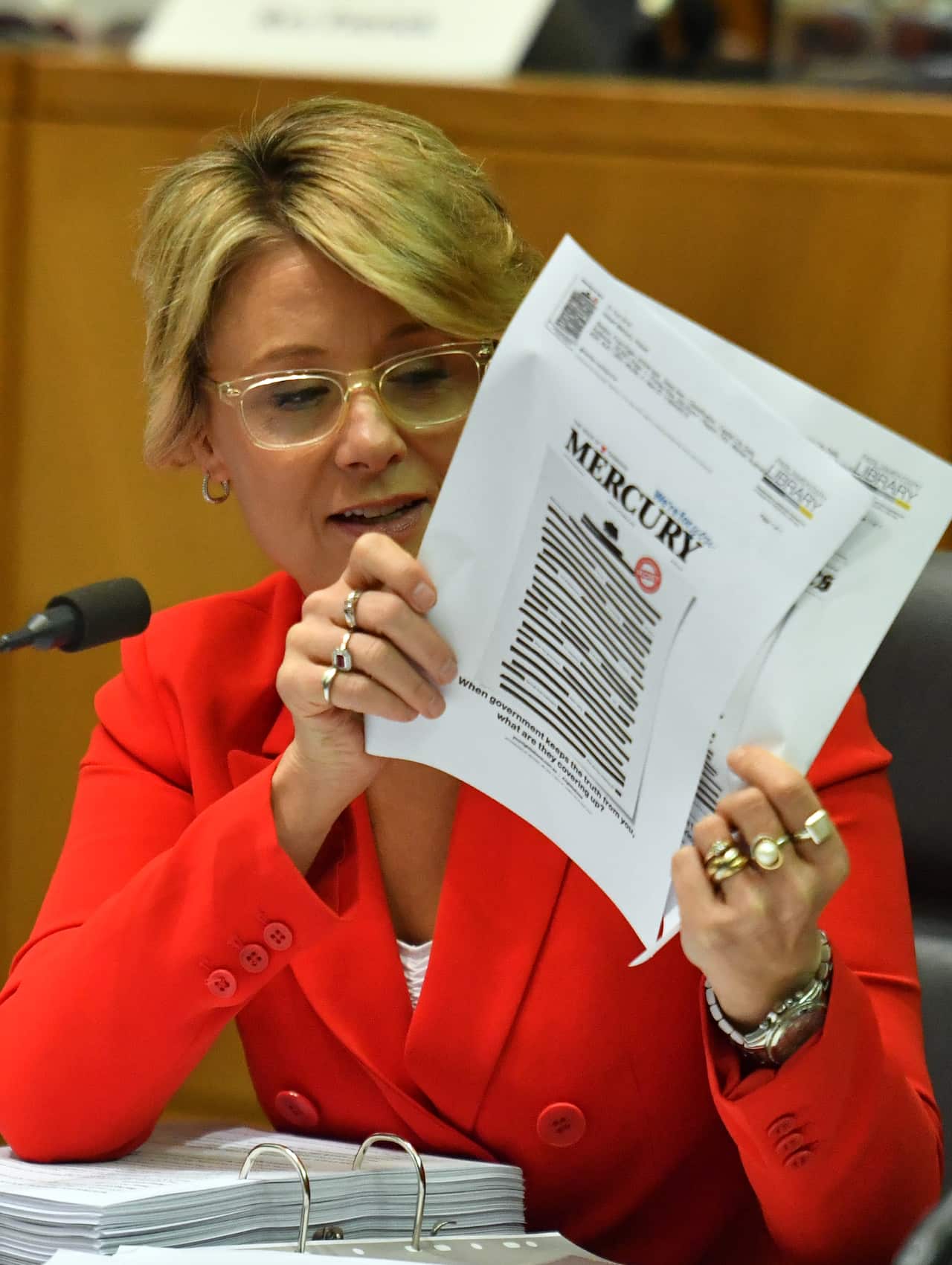Labor Senator Kristina Keneally holds copies of Monday's newspaper front pages at a Senate Estimates.