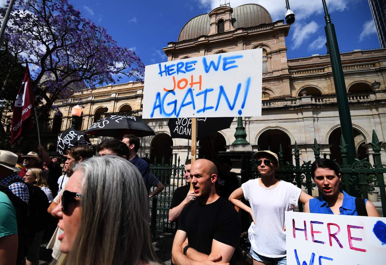 Protesters hold signs and chant during a rally against proposed laws banning the use of lock-on devices in protests.