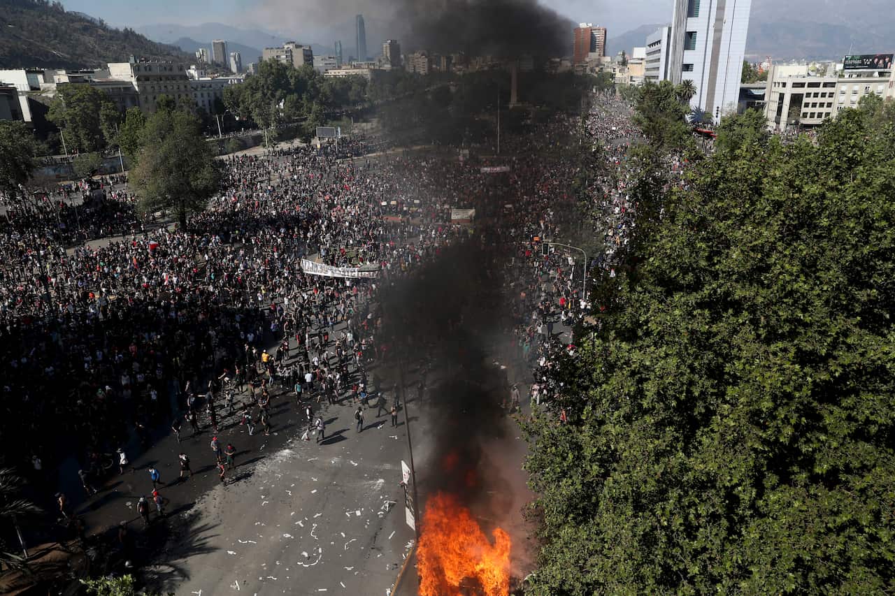 Anti-government protesters take part in a ongoing demonstrations triggered by an increase in subway fares in Santiago, Chile, 21 October.