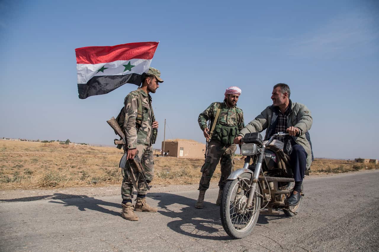 Syrian government forces man a checkpoint near the town of Tal Tamr.