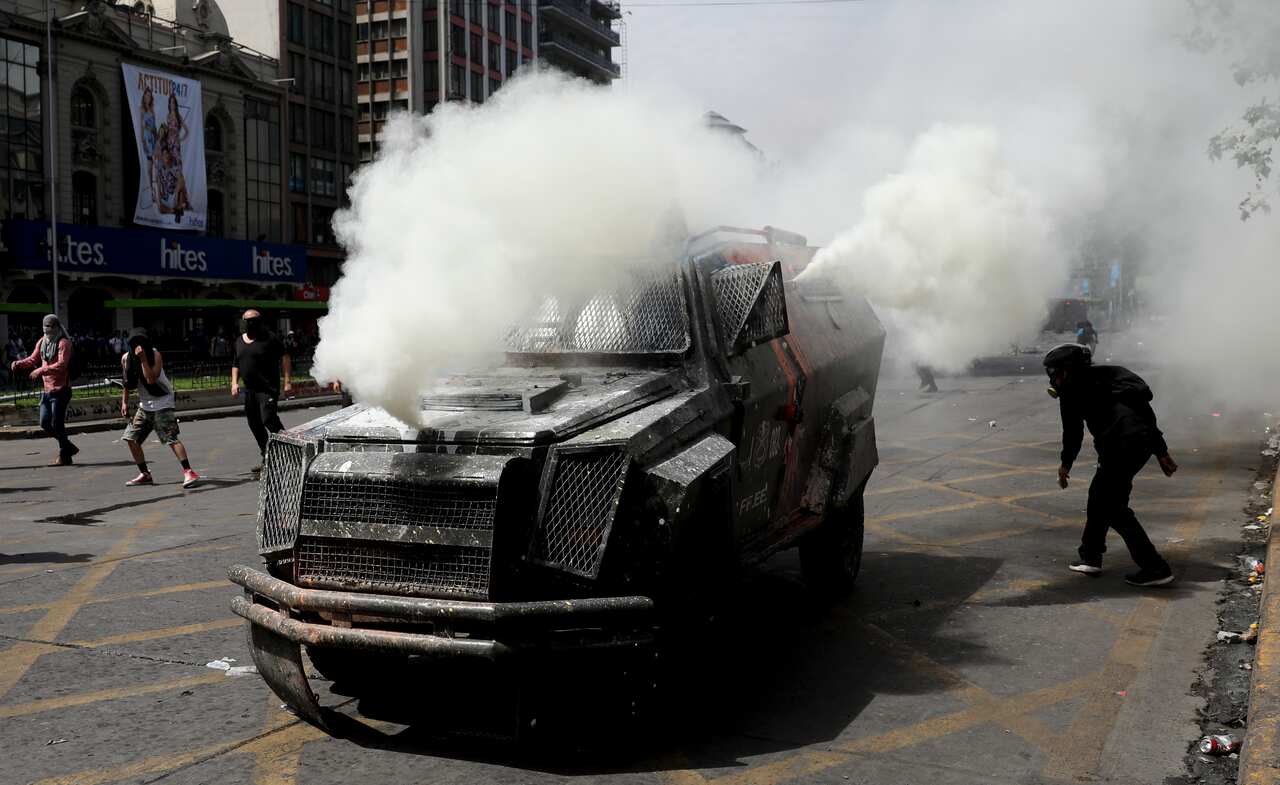 A police armored vehicle spews tear gas during clashed in Santiago, Chile.