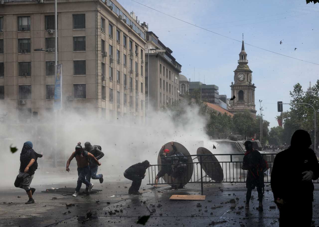Protesters run away during clashes in Santiago, Chile.