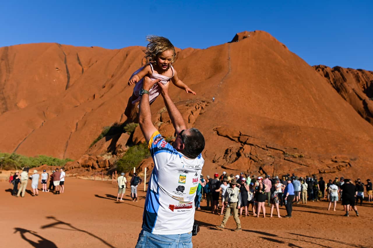 A man throws a child into the air near the climb area at Uluru-Kata Tjuta National Park in the Northern Territory.