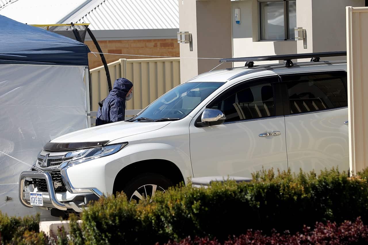 A forensic officer is seen entering the crime scene on Sunday.