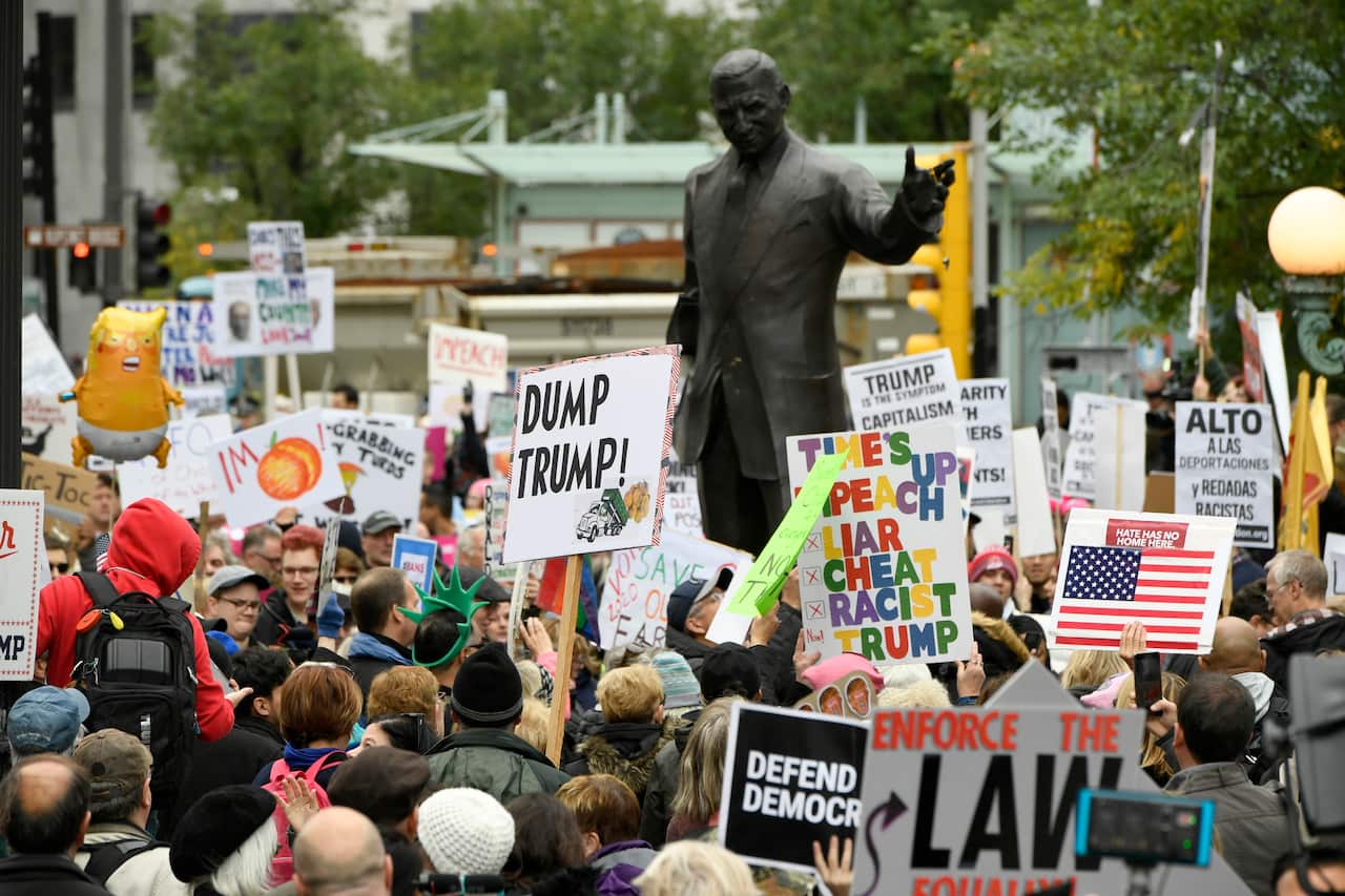 Protesters gather across the Chicago River from the Trump International Hotel and Tower while President Trump attends a fundraiser Monday, Oct. 28, 2019, in Chicago. (AP Photo/Paul Beaty)