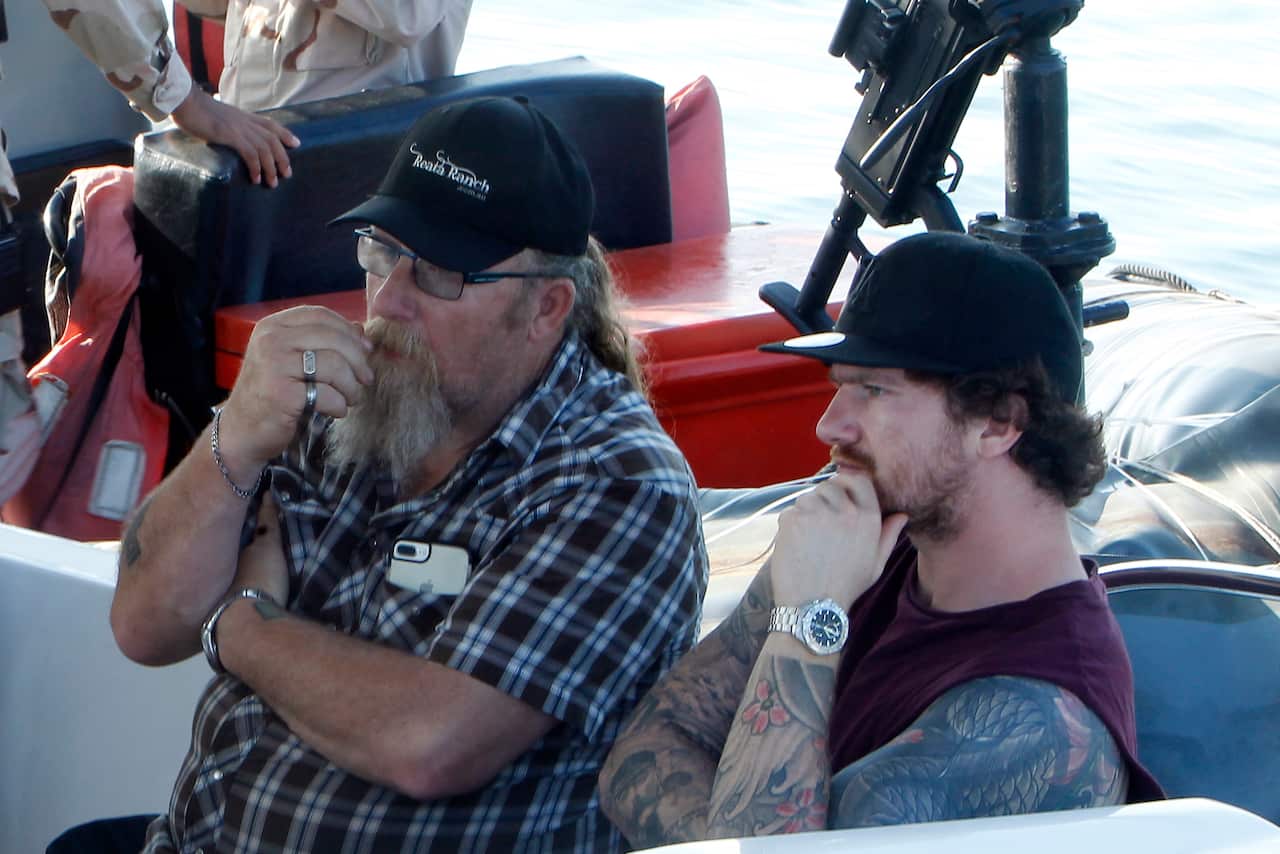 Harry Bambridge, right, brother of missing British backpacker Amelia Bambridge, sits on a speedboat before leaving to search for her.