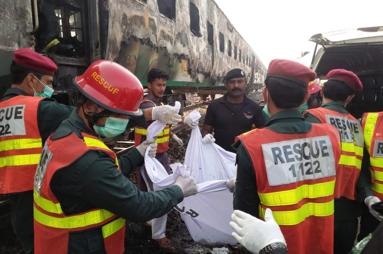 Rescue workers shift the bodies of the victims after a fire engulfed a passenger train near Rahim Yar Khan, Pakistan.
