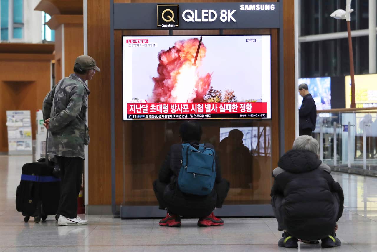 People watch a TV showing a file image of an unspecified North Korea's missile launch during a news program at the Seoul Railway Station.