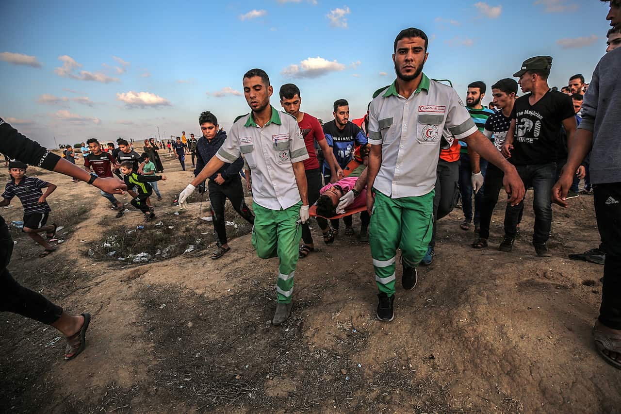 Palestinian medics carry a wounded young protester during clashes near the border between Israel and the eastern-Gaza Strip.