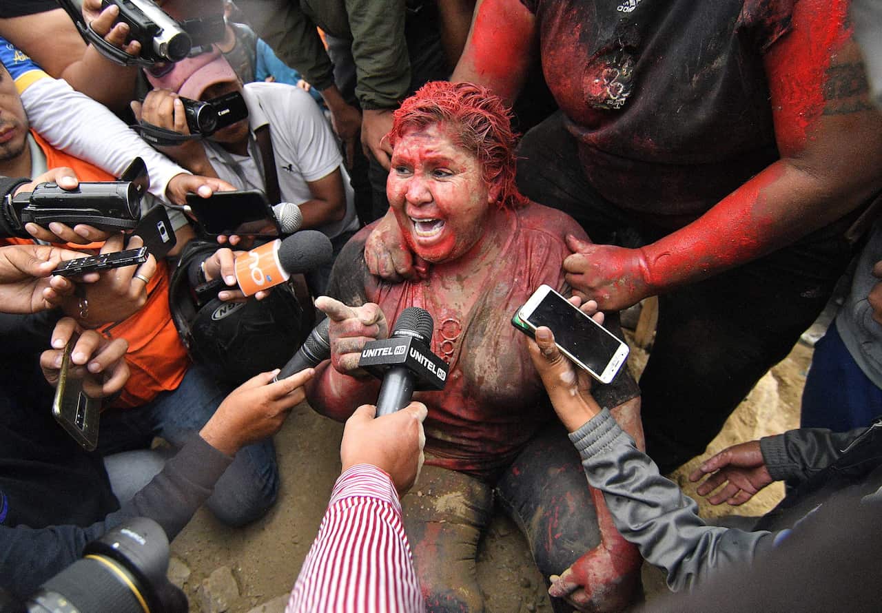 Mayor of Vinto, Patricia Arce, speaks to the media after being attacked in the street by a crowd that sprayed her with reddish paint and cut her hair. 