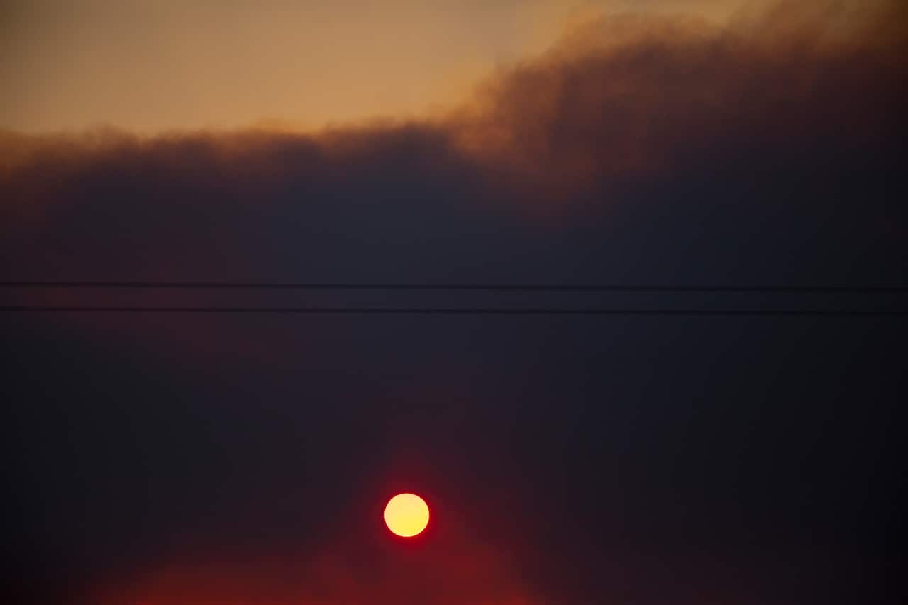 The sun rises through bushfire smoke near Taree, NSW, Saturday, November 9, 2019. Two people have been killed and seven others are msising in bushfires in NSW which have also destroyed at least 100 homes. (AAP Image/Shane Chalker) NO ARCHIVING