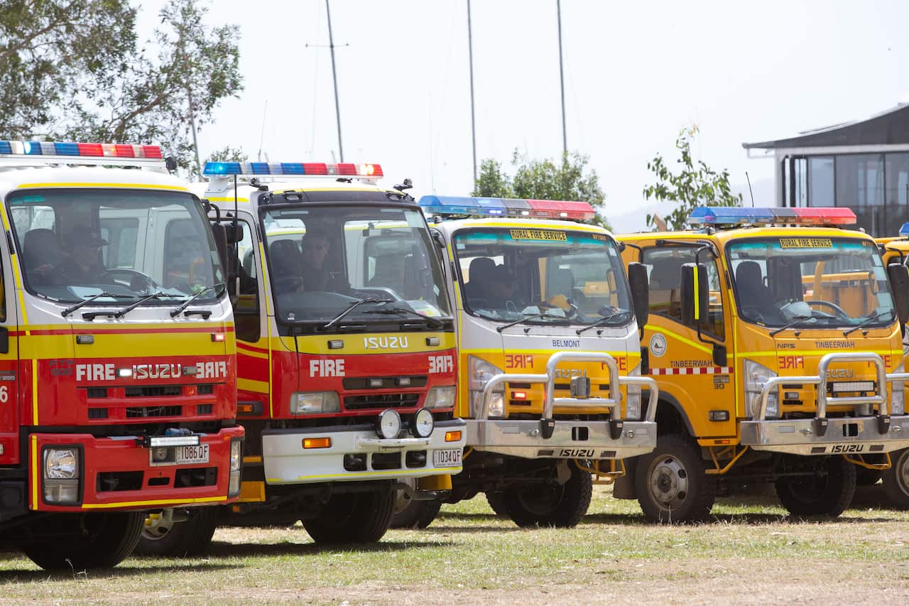 Fire trucks are seen lined up at Cooroibah in Noosa Shire, Queensland, Saturday, November 9, 2019. Thousands of residents who were evacuated from Noosa to escape the path of a bushfire are unable to go home. (AAP Image/Rob Maccoll) NO ARCHIVING