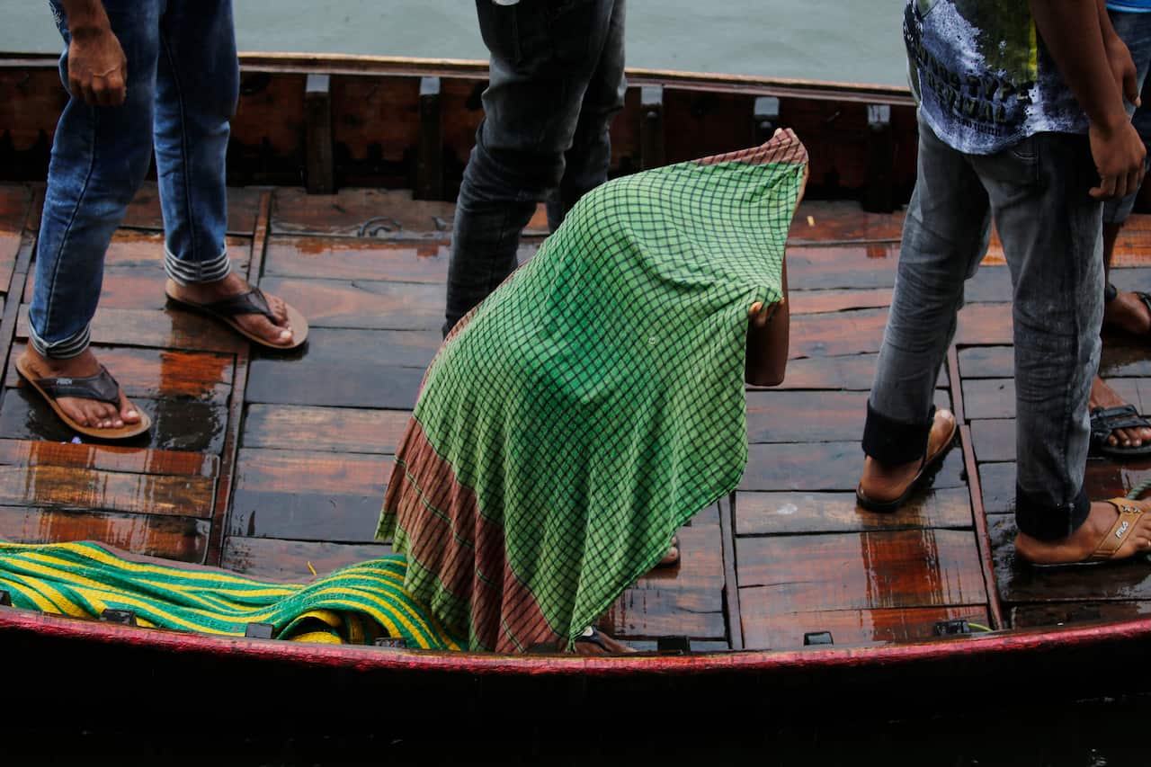 Bangladeshi passengers cover themselves with a scarf as they cross the Buriganga River by boat before Cyclone Bulbul made landfall.