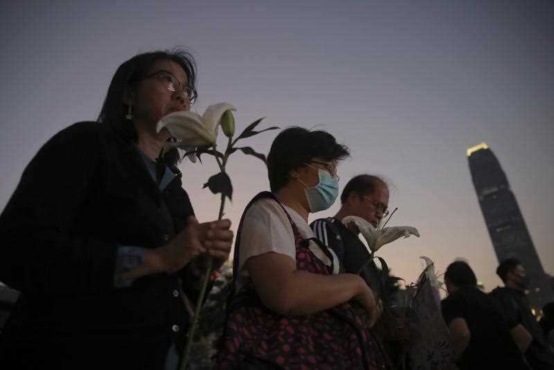 People attend a vigil for student Chow Tsz-Lok in Hong Kong, Saturday, Nov. 9, 2019.