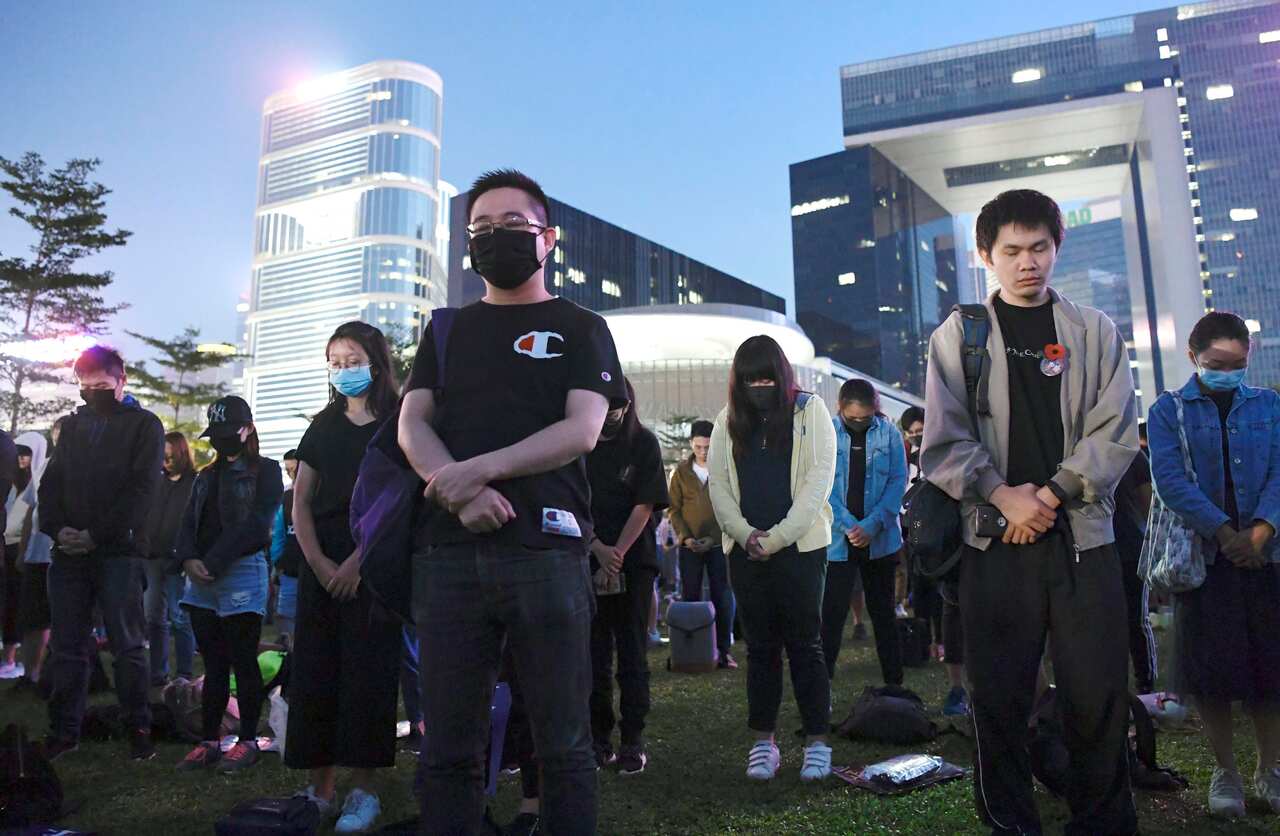 People in Hong Kong pray on Nov. 9, 2019, after a male university student fell at a multistory car park during anti-government protests, resulting in what is believed to be the first protest-related death. (Kyodo via AP Images) ==Kyodo
