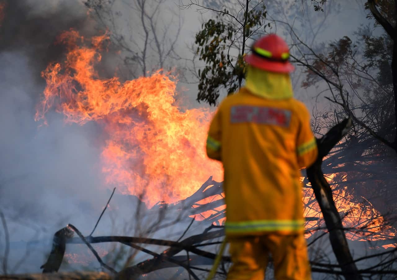 A firefighter defends a property in Torrington, near Glen Innes on Sunday.