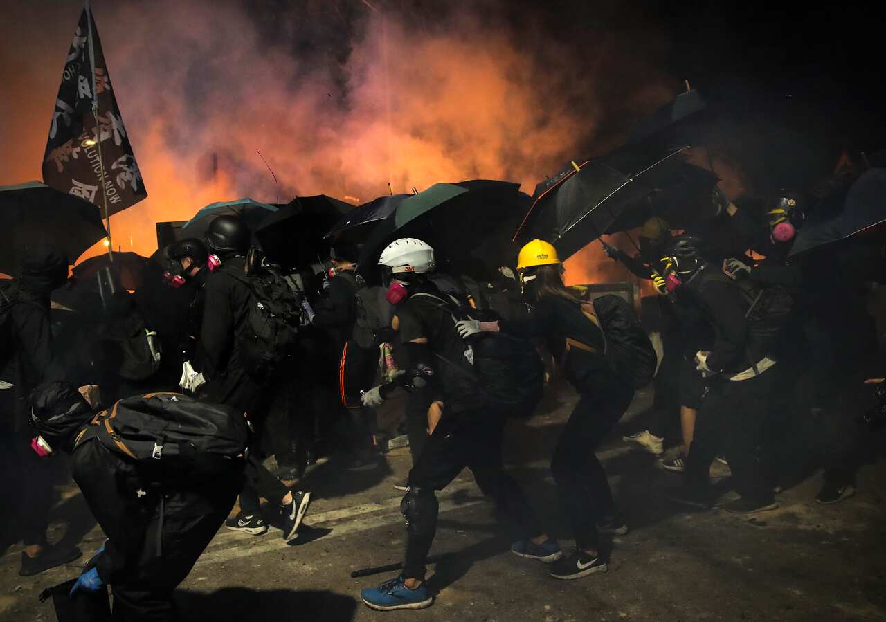 Students use umbrellas as a shield during a clash with police at the Chinese University in Hong Kong, Tuesday, Nov. 12, 2019. 