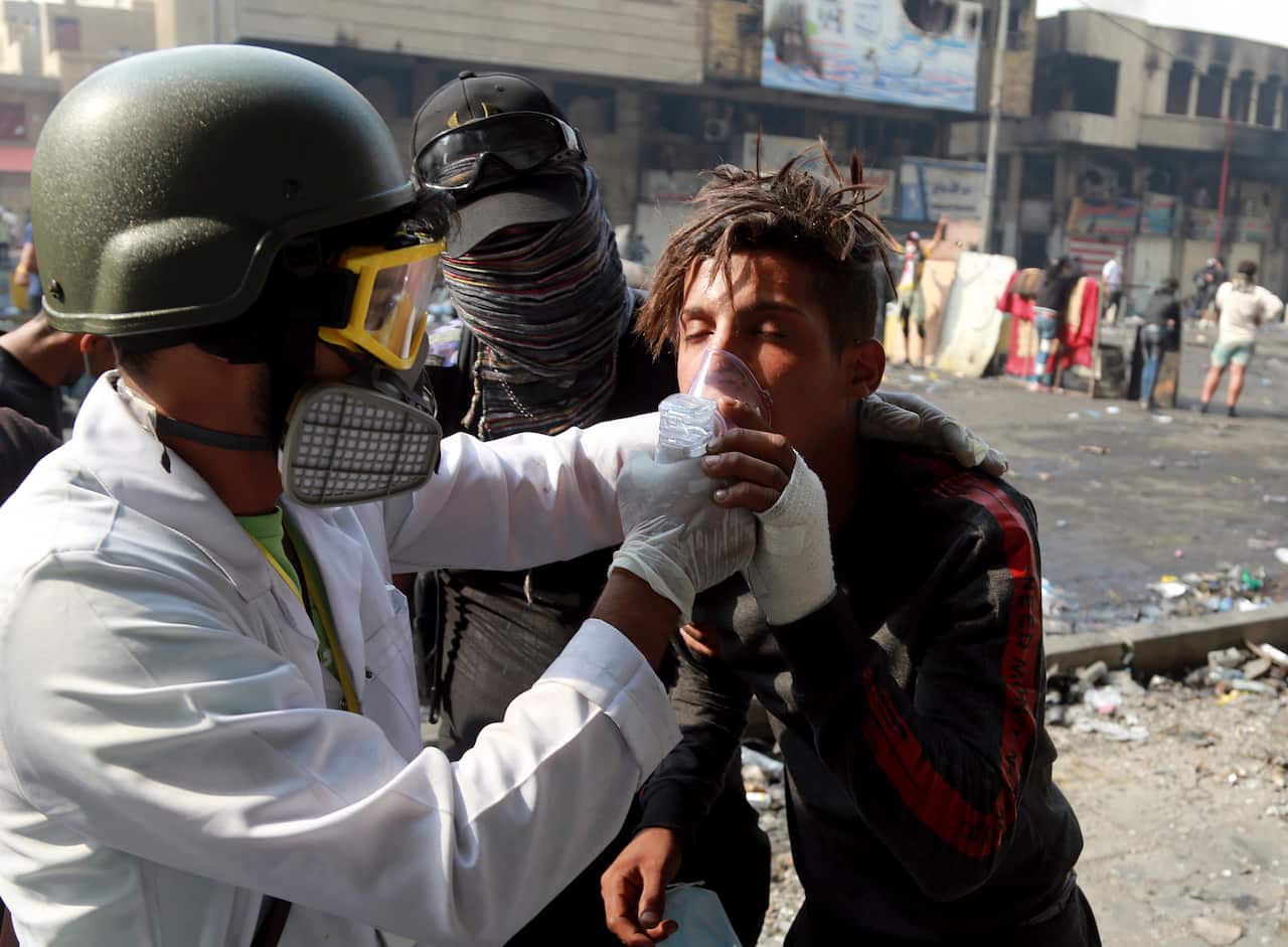An injured person receives first aid during clashes between Iraqi security forces and anti-government demonstrators, in Khilani Square in Baghdad, Iraq, Thursday, Nov. 14, 2019. (AP Photo/Hadi Mizban)
