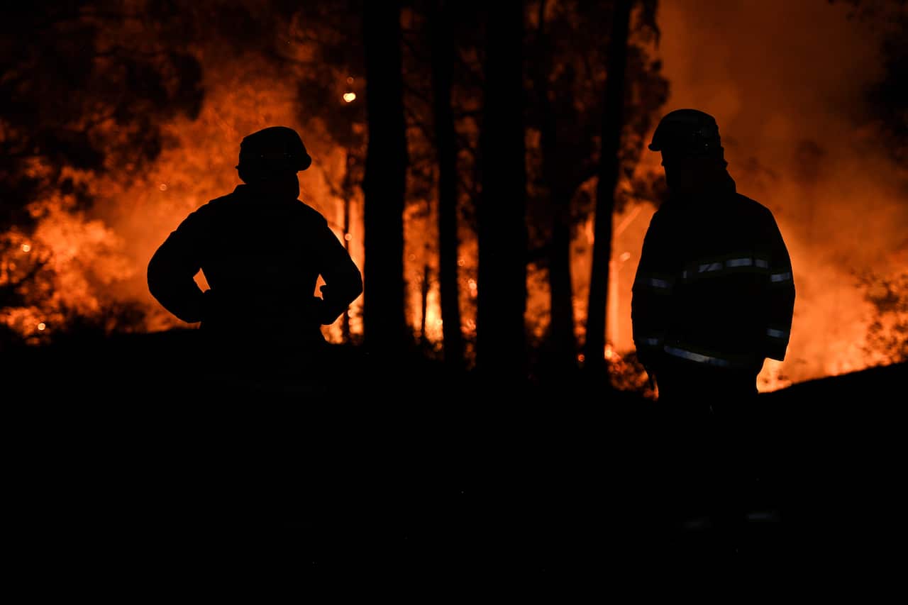 Firefighters watch on as a fire approaches a property at Colo Heights last week. 