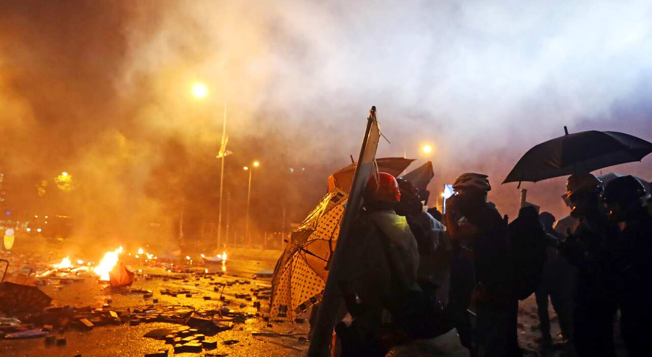 Protesters are thrown tear bombs by police officers on the street near Hong Kong Polytechnic University in Hong Kong on 17 November, 2019.
