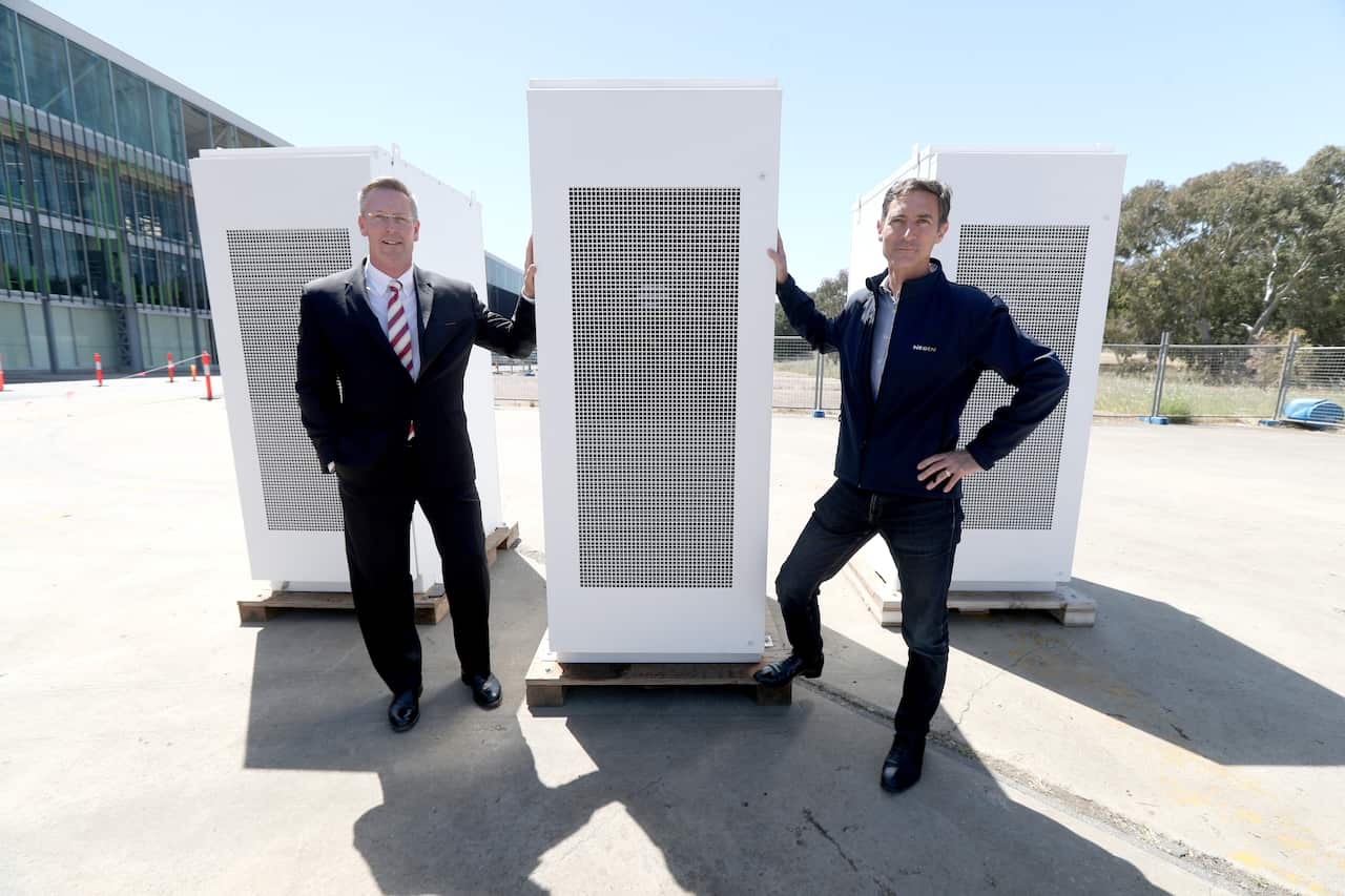 SA Energy Minister Dan van Holst Pelekaan and Neoen Australia Managing Director Louis de Sambucy pose for a photo beside a Tesla battery in Adelaide.
