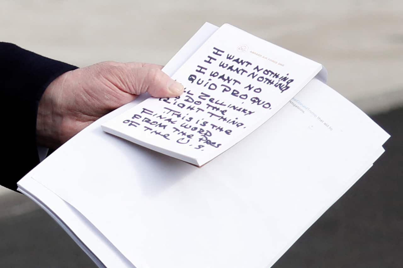US President Donald Trump held handwritten notes as he spoke to the media about the impeachment hearings.
