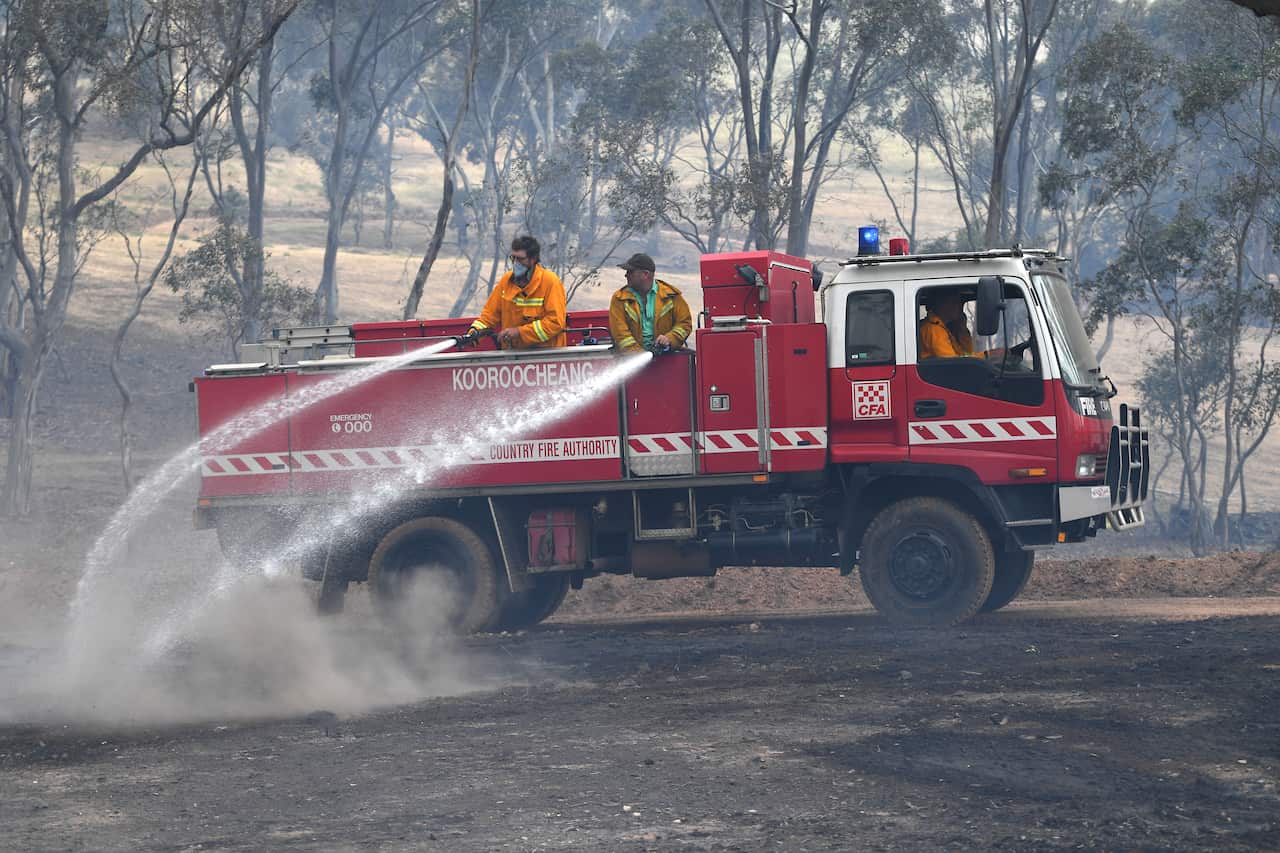 CFA firefighters are seen spraying water onto smouldering bushland at Mount Glasgow, Victoria.