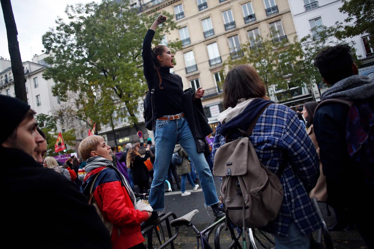 A woman gestures to the crowd as she protests against domestic violence in Paris.