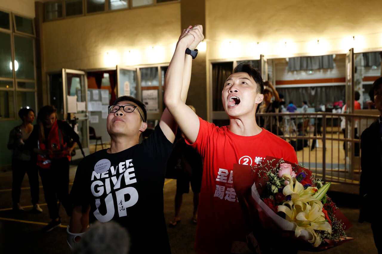 Pro-democracy candidate Jimmy Sham, right, celebrates with a supporter after winning his election in Hong Kong.