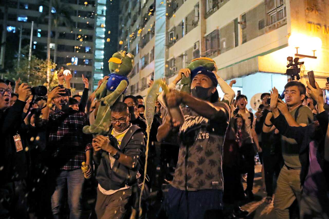 Pro-democracy supporters celebrate after pro-Beijing politician Junius Ho lost his election in Hong Kong.