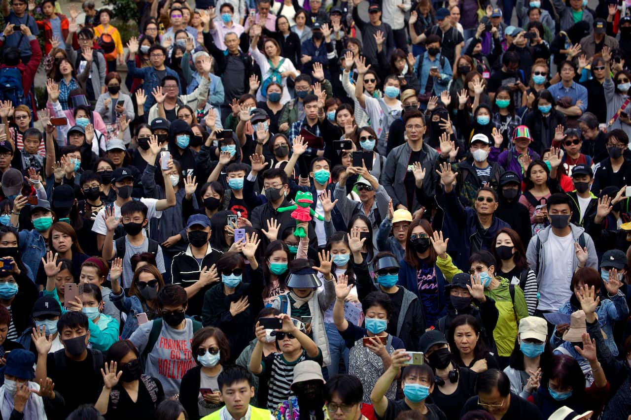 Protesters raise their hand to symbolize the five demands of the pro-democracy movement.