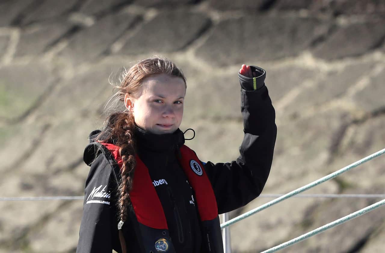 Climate activist Greta Thunberg waves as she arrives in Lisbon aboard the sailboat to attend the COP25.